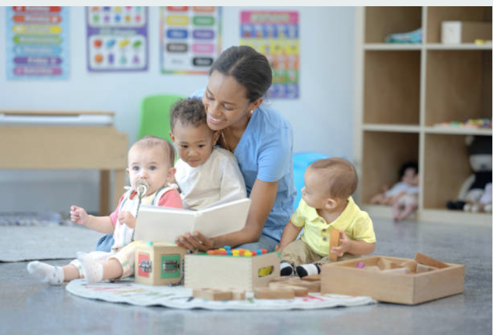 Caring teacher reading to infants in a nurturing environment