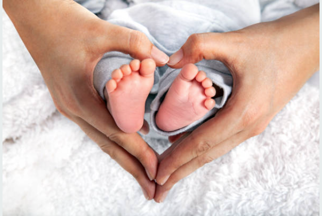 Newborn baby feet held gently in parents hands