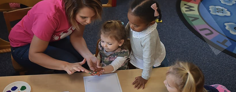 Teacher helping child paint