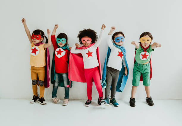 Children in superhero costumes standing confident and strong