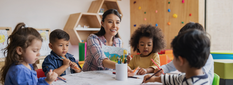 Teacher engaging with diverse children at a table
