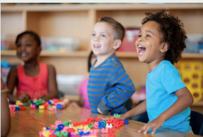 Children laughing and playing with colorful building blocks
