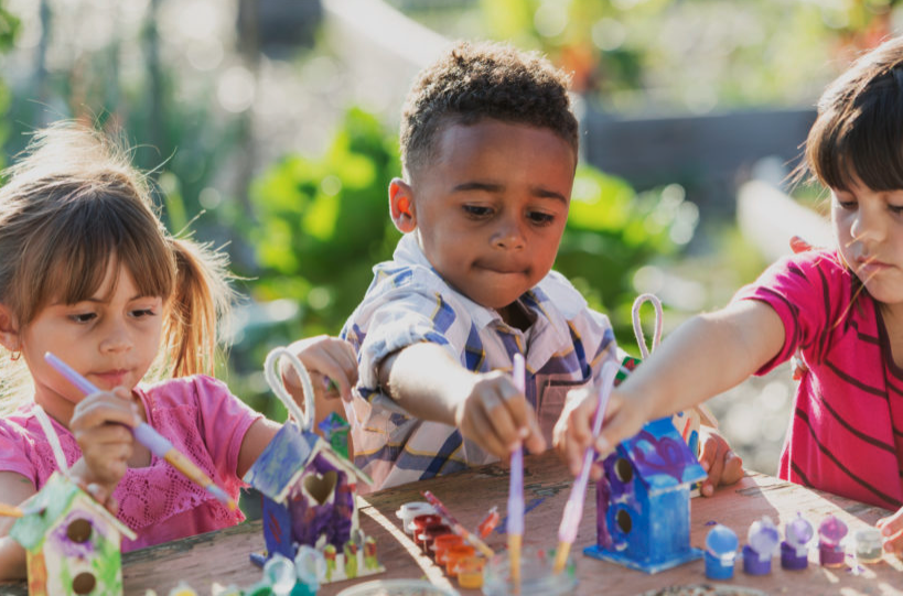 Children creating art outdoors in summer sunshine